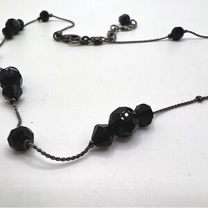 Vintage silver toned necklace adorned with black faceted glass beads.